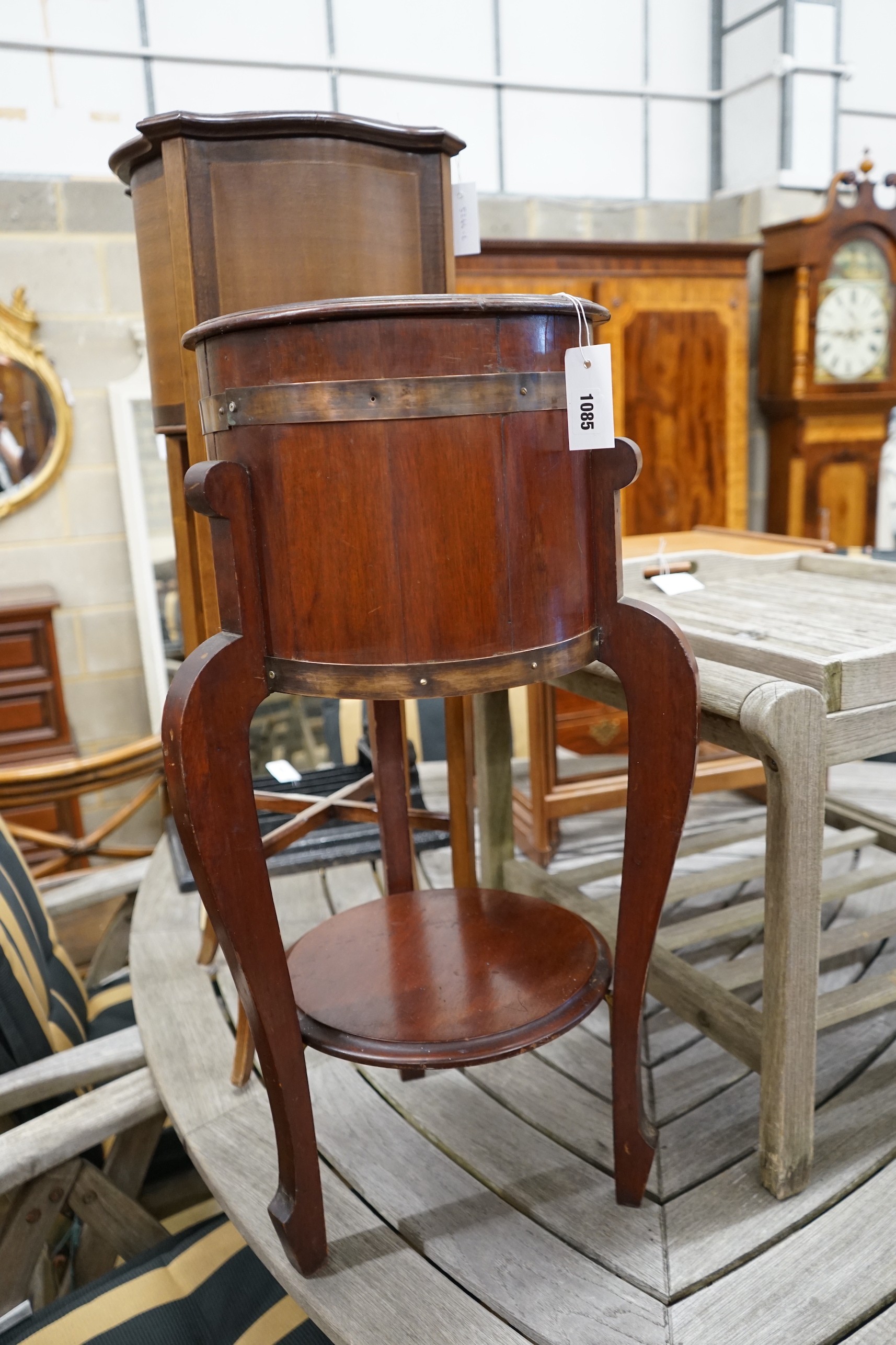 An Arts and Crafts brass bound staved mahogany circular jardiniere, diameter 35cm, height 78cm